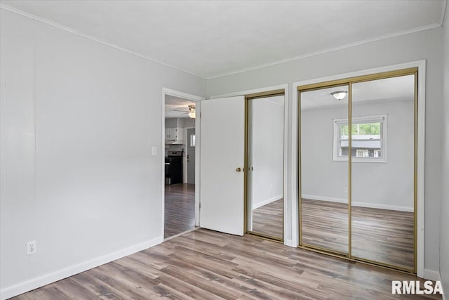 8 Melody Ln, Springfield, IL 62702 - unfurnished bedroom with ornamental molding, multiple closets, wood finished floors, and baseboards