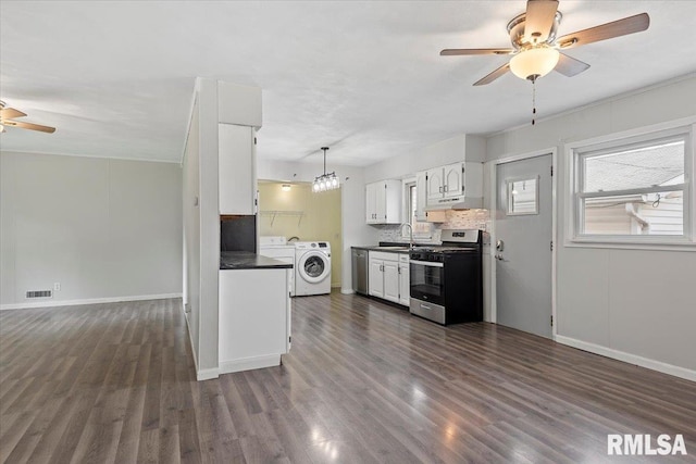 8 Melody Ln, Springfield, IL 62702 - kitchen with appliances with stainless steel finishes, a ceiling fan, washer and dryer, dark countertops, and a sink