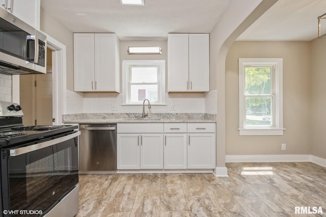 2428 S 8th St, Springfield, IL 62703 - kitchen with stainless steel appliances, a sink, white cabinetry, tasteful backsplash, and light stone countertops