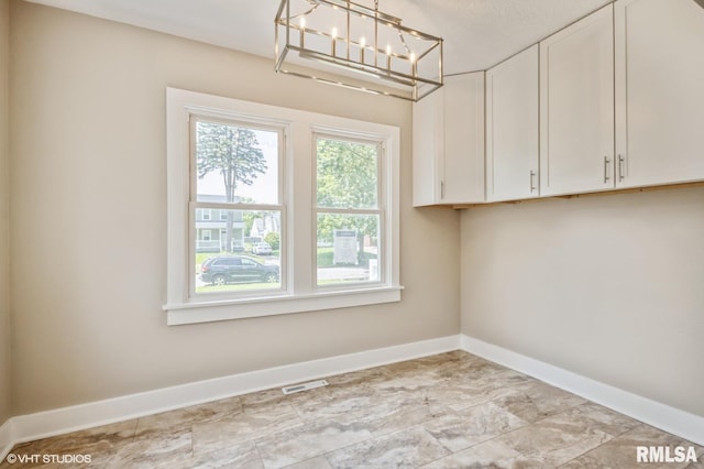 2428 S 8th St, Springfield, IL 62703 - washroom featuring baseboards and a chandelier