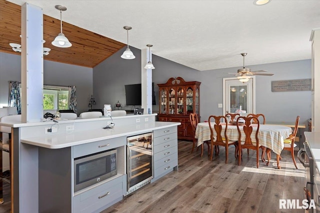 4101 N 8th St, Springfield, IL 62707 - kitchen featuring wine cooler, stainless steel microwave, vaulted ceiling, light wood finished floors, and gray cabinetry