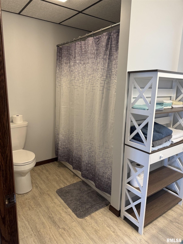 18382 N Quiver Beach Rd, Havana, IL 62644 - bathroom featuring wood finished floors, toilet, baseboards, and curtained shower