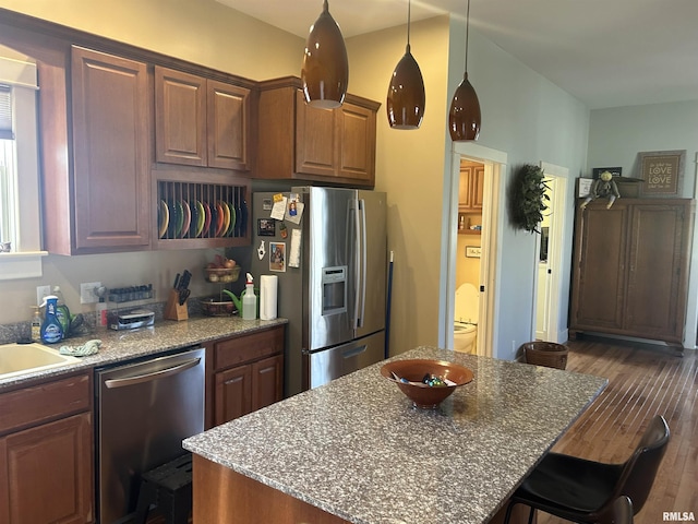 118 W Clark St, Havana, IL 62644 - kitchen featuring stainless steel appliances, a breakfast bar, a center island, light stone countertops, and dark wood-style flooring