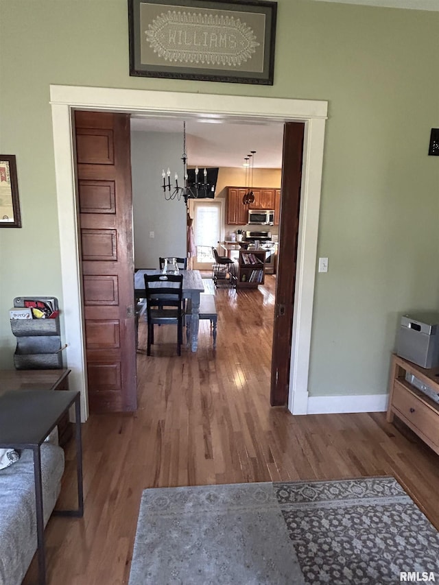 118 W Clark St, Havana, IL 62644 - hallway featuring a chandelier, wood finished floors, and baseboards