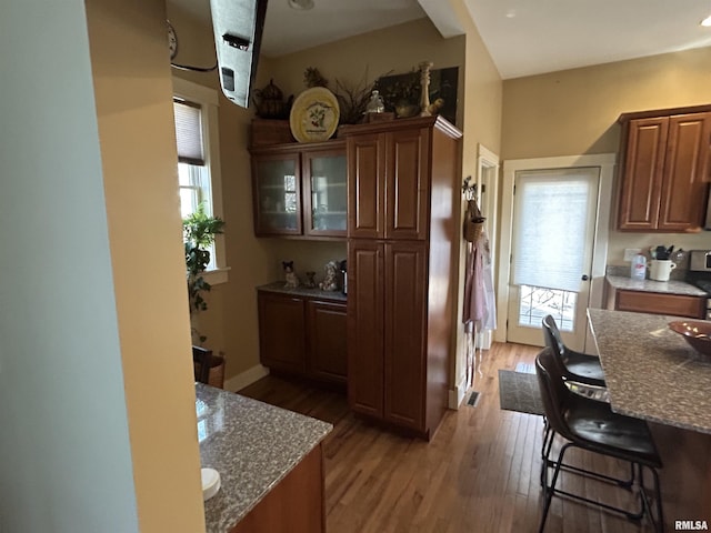 118 W Clark St, Havana, IL 62644 - kitchen with light wood-style floors, plenty of natural light, a kitchen breakfast bar, and stone counters
