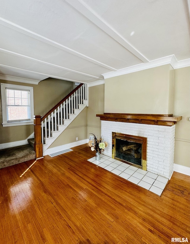 1595 N Kellogg St, Galesburg, IL 61401 - unfurnished living room with hardwood / wood-style floors, baseboards, crown molding, stairs, and a fireplace