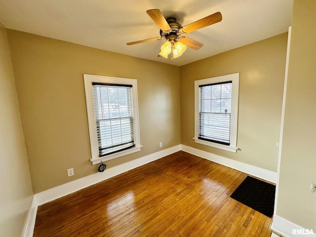 1595 N Kellogg St, Galesburg, IL 61401 - unfurnished room with wood-type flooring, plenty of natural light, baseboards, and a ceiling fan