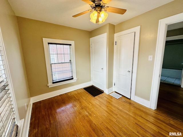 1595 N Kellogg St, Galesburg, IL 61401 - unfurnished bedroom featuring wood finished floors, baseboards, and ceiling fan