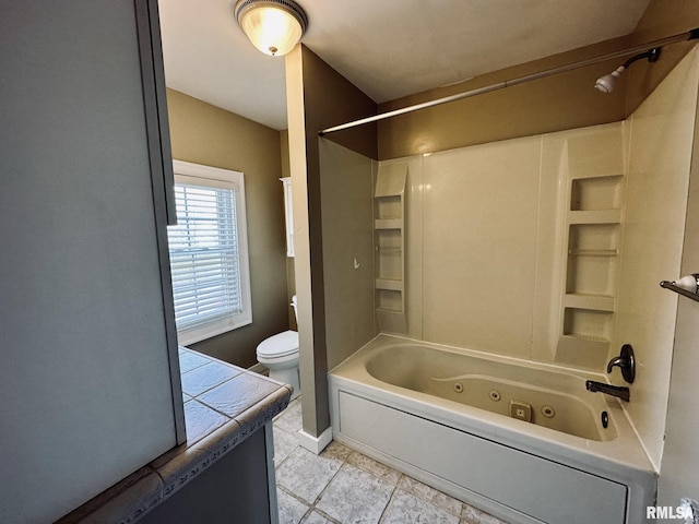 1595 N Kellogg St, Galesburg, IL 61401 - full bath featuring toilet, a combined bath / shower with jetted tub, vanity, tile patterned flooring, and baseboards