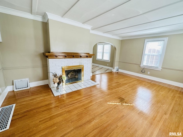 1595 N Kellogg St, Galesburg, IL 61401 - unfurnished living room with wood finished floors, a brick fireplace, baseboards, ornamental molding, and arched walkways