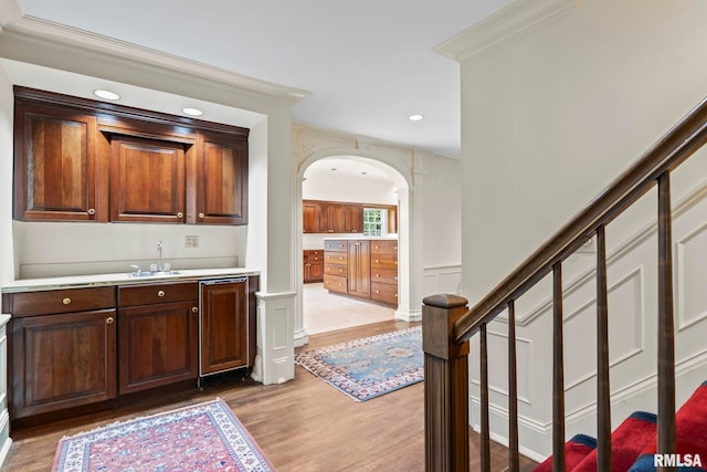 1044 Williams Blvd, Springfield, IL 62704 - indoor wet bar featuring light wood-style floors, arched walkways, stairway, recessed lighting, and crown molding