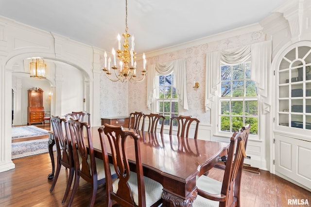1044 Williams Blvd, Springfield, IL 62704 - dining space featuring a chandelier, wood finished floors, wallpapered walls, crown molding, and arched walkways