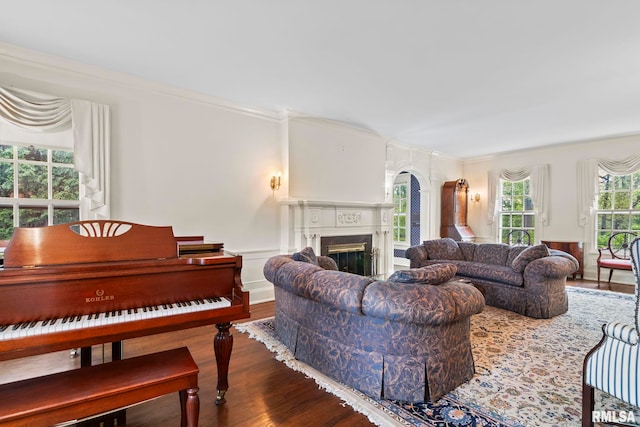 1044 Williams Blvd, Springfield, IL 62704 - living area featuring wood finished floors, a glass covered fireplace, crown molding, arched walkways, and a decorative wall