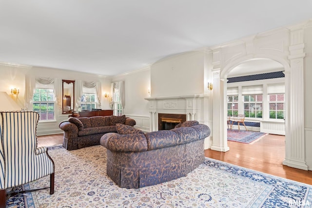 1044 Williams Blvd, Springfield, IL 62704 - living room featuring a decorative wall, crown molding, a fireplace, wood finished floors, and arched walkways