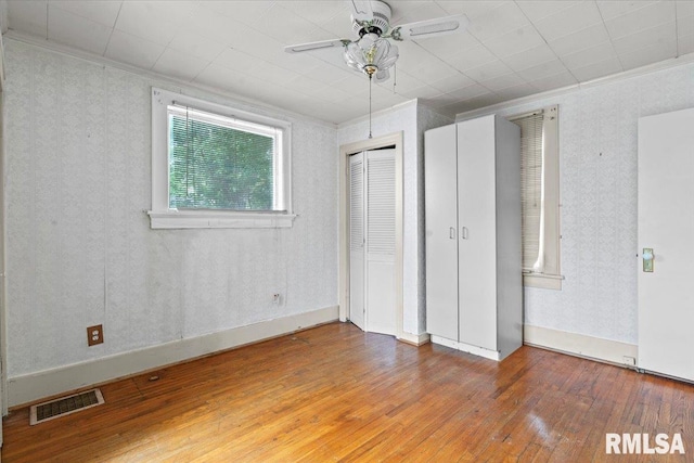 1708 Holmes Ave, Springfield, IL 62704 - unfurnished bedroom with wood-type flooring, crown molding, and a ceiling fan