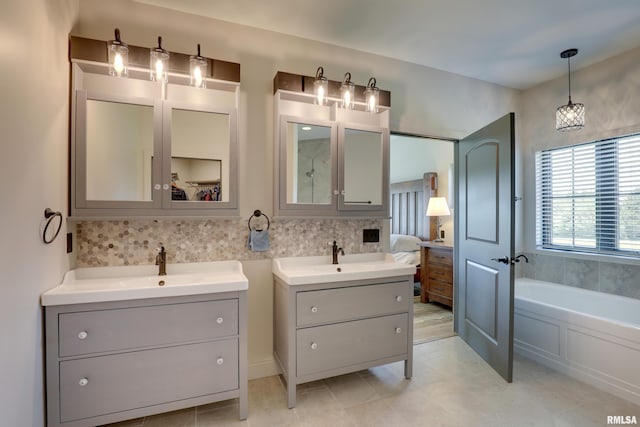 4811 Bitter Ct, Quincy, IL 62305 - full bath with two vanities, ensuite bath, a garden tub, and tile patterned flooring