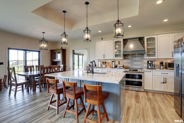 4811 Bitter Ct, Quincy, IL 62305 - kitchen with appliances with stainless steel finishes, wall chimney exhaust hood, plenty of natural light, light wood-type flooring, and recessed lighting