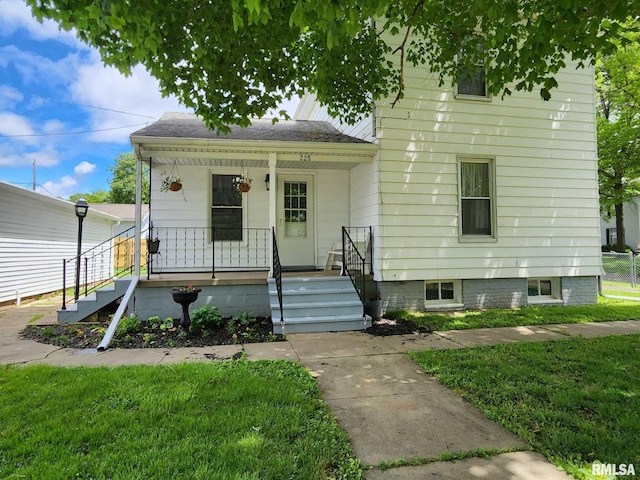 228 4th St, Lincoln, IL 62656 - view of front facade featuring a porch and a front yard