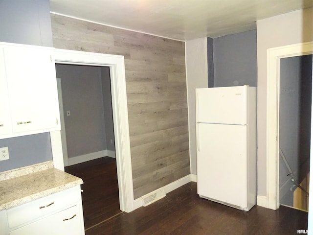 2536 S 10th St, Springfield, IL 62703 - kitchen featuring freestanding refrigerator, wooden walls, dark wood-style flooring, white cabinetry, and baseboards