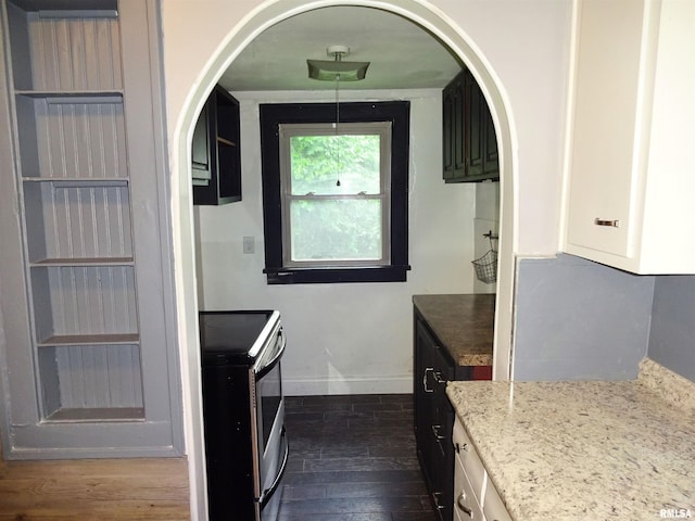 2536 S 10th St, Springfield, IL 62703 - kitchen with stainless steel electric stove, dark wood-style flooring, baseboards, light stone countertops, and arched walkways