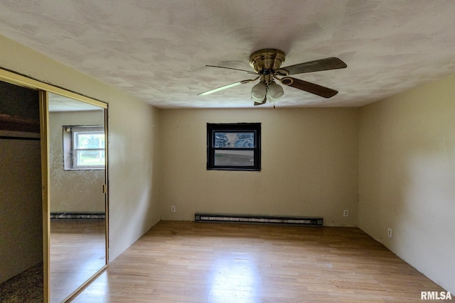 30 Ryder St, Nilwood, IL 62672 - unfurnished bedroom with a baseboard radiator, light wood-style floors, a closet, and a ceiling fan