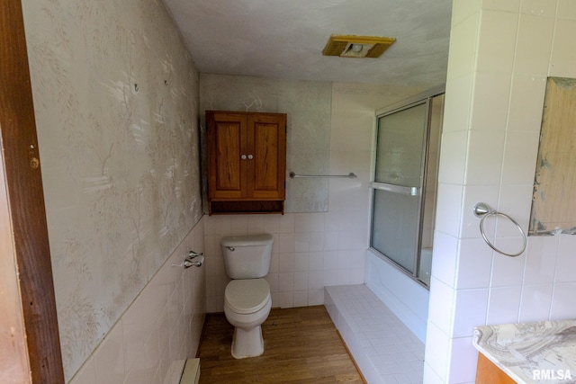 30 Ryder St, Nilwood, IL 62672 - bathroom featuring toilet, tile walls, wood finished floors, and combined bath / shower with glass door