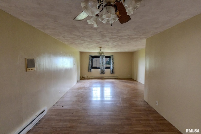 30 Ryder St, Nilwood, IL 62672 - unfurnished room with a baseboard radiator, a ceiling fan, wood finished floors, and a chandelier
