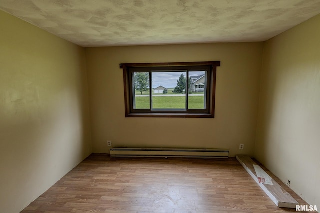 30 Ryder St, Nilwood, IL 62672 - empty room featuring light wood finished floors and a baseboard heating unit