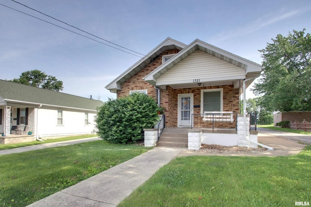 1321 Locust St, Quincy, IL 62301 - view of front of house featuring a porch, a front lawn, and brick siding