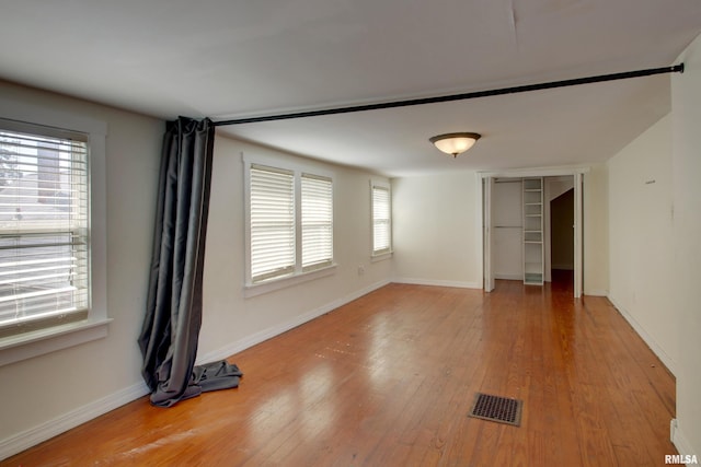 1321 Locust St, Quincy, IL 62301 - unfurnished bedroom with multiple windows, light wood-style floors, and baseboards
