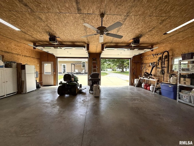 709 W Monmouth St, Abingdon, IL 61410 - garage with freestanding refrigerator, a garage door opener, and a ceiling fan