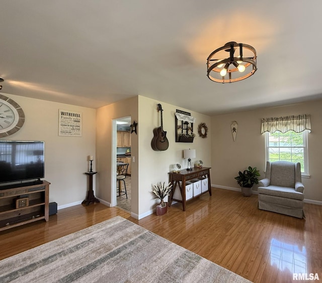 709 W Monmouth St, Abingdon, IL 61410 - living room featuring wood finished floors, a chandelier, and baseboards