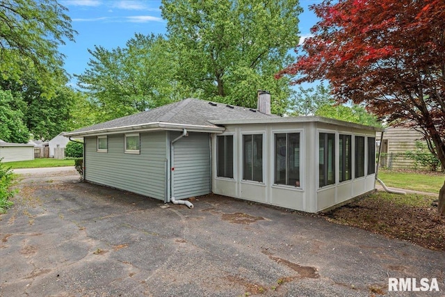 3225 Saxony Rd, Springfield, IL 62703 - back of house with a chimney, a sunroom, and a shingled roof