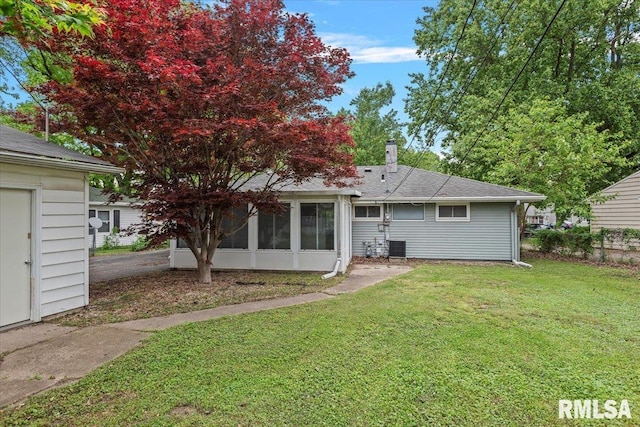 3225 Saxony Rd, Springfield, IL 62703 - rear view of property featuring a lawn, a sunroom, central AC unit, and roof with shingles