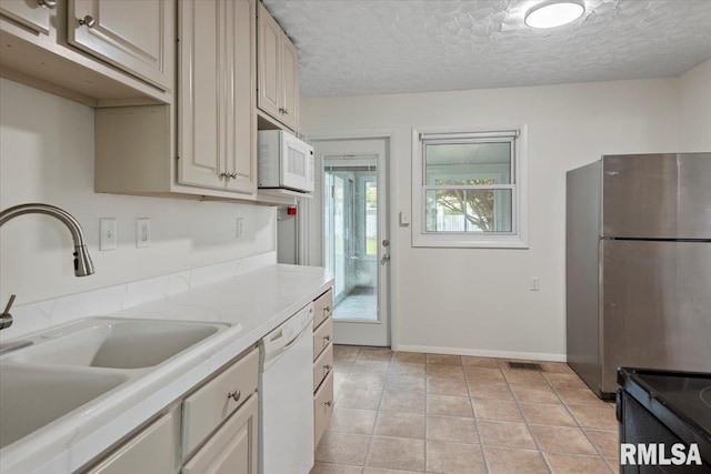 3225 Saxony Rd, Springfield, IL 62703 - kitchen with white appliances, a sink, light countertops, baseboards, and a textured ceiling