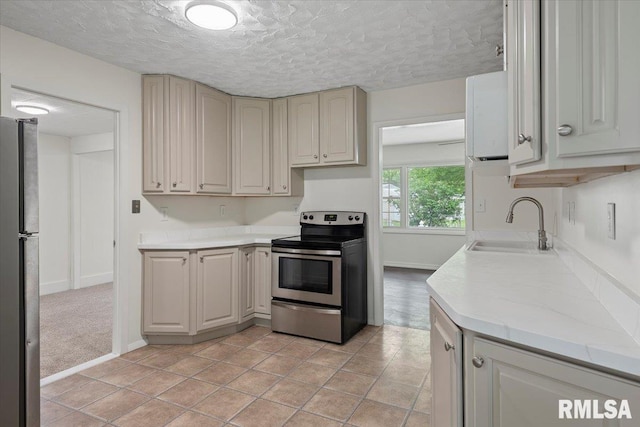 3225 Saxony Rd, Springfield, IL 62703 - kitchen with appliances with stainless steel finishes, a sink, light countertops, a textured ceiling, and baseboards