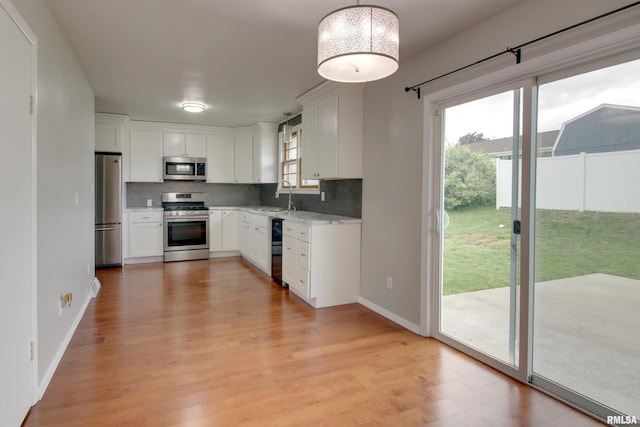 3705 Briarwood Dr, Quincy, IL 62301 - kitchen with stainless steel appliances, a sink, decorative backsplash, and light wood-type flooring