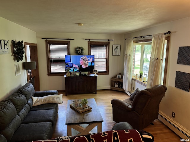 409 N Broadway St, Havana, IL 62644 - living area with a baseboard heating unit, wood finished floors, and baseboards