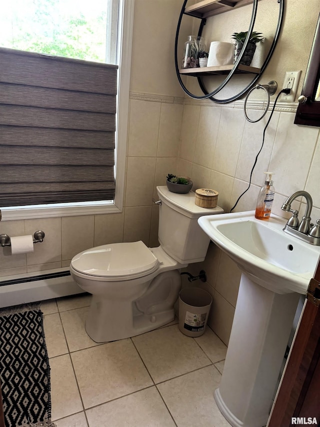 409 N Broadway St, Havana, IL 62644 - half bath with tile walls, a baseboard heating unit, toilet, tile patterned flooring, and a sink