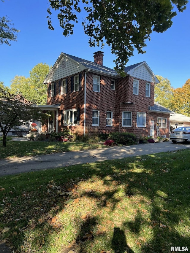 409 N Broadway St, Havana, IL 62644 - view of front facade with a chimney, a front lawn, and brick siding
