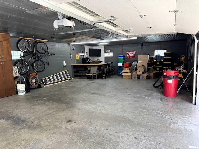 409 N Broadway St, Havana, IL 62644 - garage featuring concrete block wall, a garage door opener, and a workshop area
