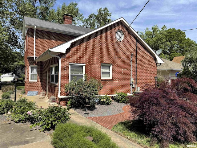 409 N Broadway St, Havana, IL 62644 - view of side of home with brick siding, a chimney, and a patio area