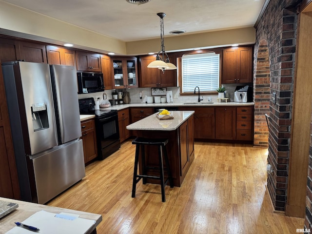 409 N Broadway St, Havana, IL 62644 - kitchen featuring black appliances, a sink, light wood-style floors, and tasteful backsplash