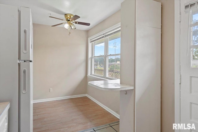 2309 W Lawrence Ave, Springfield, IL 62704 - unfurnished dining area featuring a ceiling fan, baseboards, and light wood-style floors