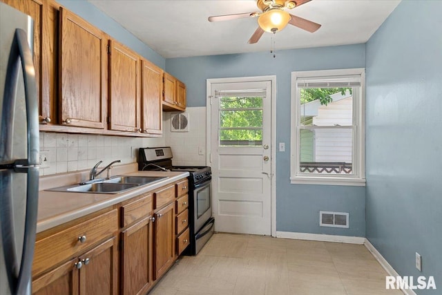 2309 W Lawrence Ave, Springfield, IL 62704 - kitchen with range with gas stovetop, a sink, light countertops, freestanding refrigerator, and decorative backsplash