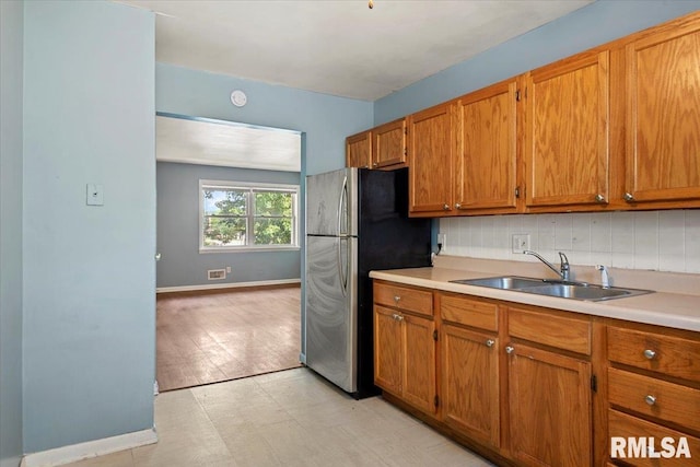 2309 W Lawrence Ave, Springfield, IL 62704 - kitchen with a sink, freestanding refrigerator, and brown cabinetry