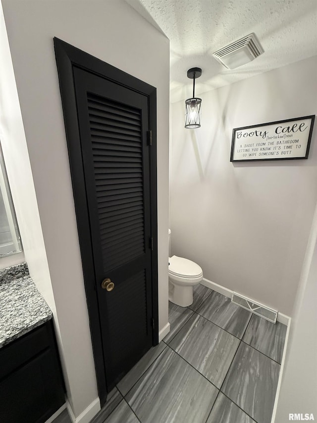 1352 N Lawrence Ave, Taylorville, IL 62568 - bathroom featuring toilet, baseboards, vanity, and a textured ceiling