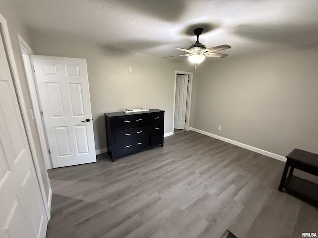 1352 N Lawrence Ave, Taylorville, IL 62568 - unfurnished bedroom featuring wood finished floors, baseboards, a textured ceiling, and ceiling fan