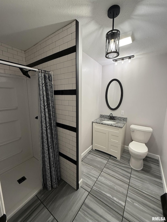 1352 N Lawrence Ave, Taylorville, IL 62568 - bathroom featuring a stall shower, vanity, toilet, a textured ceiling, and baseboards
