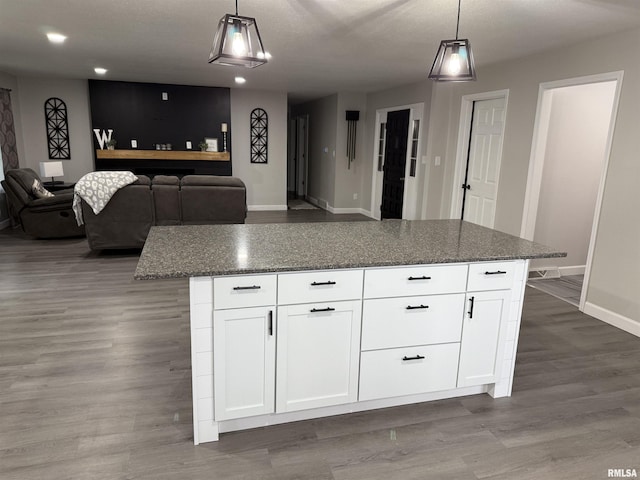1352 N Lawrence Ave, Taylorville, IL 62568 - kitchen featuring baseboards, wood finished floors, decorative light fixtures, white cabinetry, and dark stone counters